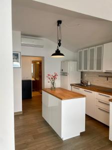 斯楚雅Seafront Apartment Strunjan的厨房配有白色橱柜和木制台面