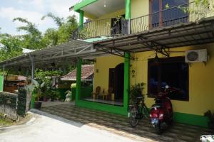 RanduguntingOmah Bogem Homestay Syariah的一辆摩托车停在房子前面