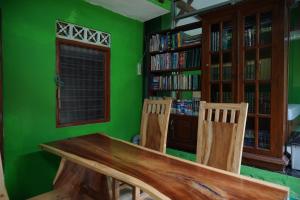 RanduguntingOmah Bogem Homestay Syariah的绿色的客房配有木桌和两把椅子