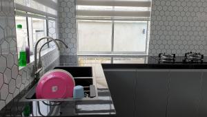 Guar ChempedakEl Manzil Homestay with Pool的厨房配有水槽内的粉红色板
