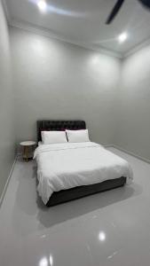 Guar ChempedakEl Manzil Homestay with Pool的白色卧室配有床和桌子