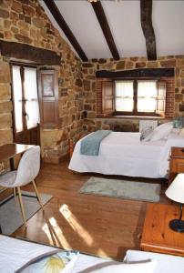 SelayaCasa Rural Los Riveros de Jeromo的一间卧室设有两张床和砖墙