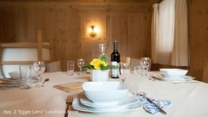 安罗斯Landhaus & Schloss Anras的一张带盘子和玻璃杯的桌子和一瓶葡萄酒