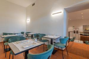 古比奥加特鹏酒店的一间配备有桌子和蓝色椅子的用餐室