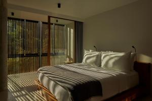 EkasInnit Lombok的卧室配有带白色枕头的大床