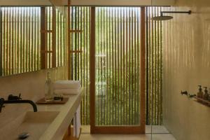 EkasInnit Lombok的一间带水槽和淋浴及窗户的浴室