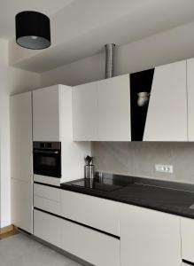 弗留利地区奇维达莱Domus terme romane的厨房配有白色橱柜和炉灶烤箱。