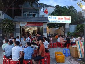 隆海Nhà nghỉ Thiên Thanh 1的一群坐在餐厅前桌旁的人