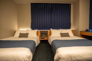 美瑛町UUHOME的酒店客房设有两张床和窗户。