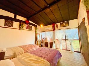 长野一棟貸し切り バリの雰囲気を楽しめる古民家vintagehouse1925Bali的一间卧室设有一张床和一个大窗户