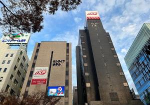 福冈TKP Sunlife Hotel的一座高大的建筑,上面有钟