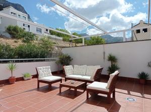 卡索拉恩特里奥斯公寓酒店的阳台的天井配有2把椅子和1张桌子