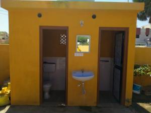 普杰Patel's Home的黄色的浴室设有水槽和卫生间