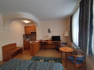 米什科尔茨潘诺尼亚酒店的客房设有一张床、一张书桌和一间厨房