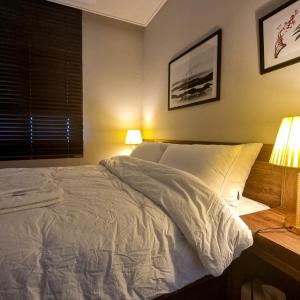 平泽市Humphreys 2 min Vintage Korean Room的一间卧室配有一张带两盏灯的床和一扇窗户。