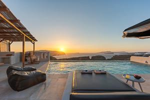梅加洛克里Ambeli Sunset Villas的日落时分享有海洋美景的游泳池