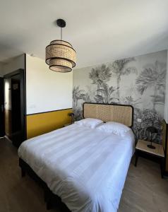 Saint-Vigor-le-GrandDOMAINE DU GRAND CAUGY的一间卧室配有一张带热带壁纸的大床
