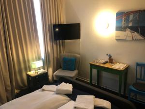 威廉港City Hostel by beans parc的酒店客房配有一张床、一把椅子和一张书桌