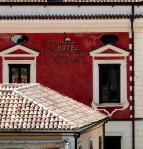 提加亚诺安缇基费乌帝迪莫拉德波卡酒店的红色的建筑,有两个窗户,上面有标志