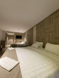 亚喀巴mass paradise2的卧室内的一张大白色床,卧室内有墙壁