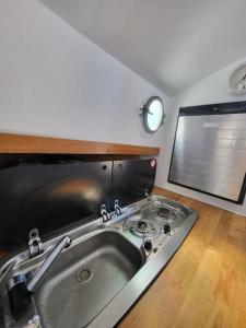不莱梅Holländisches Kajütboot Nixe的带窗户的客房内设有带水槽的厨房