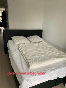 克诺克－海斯特Nieuwbouwappartement Lippenslaan, 2 -Slaapkamers的一张带白色床单和枕头的床