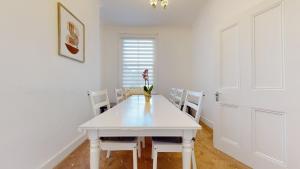 伦敦Cheerful 4 Bedroom Victorian house with back courtyard的白色的用餐室配有白色的桌椅