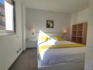 马塔罗Mazi Apartments Nest的白色卧室配有一张带黄色床单的大床