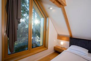 布莱德Ambient Resort Bled的一间卧室设有一张床和一个大窗户