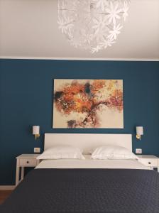 木洛希尼Neda Apartmani的卧室配有一张床,墙上挂有绘画作品