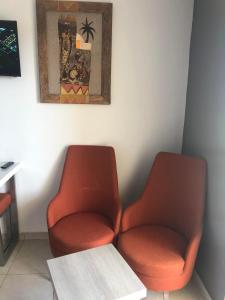 杰尔吉斯Eden Star Resort的一张桌子的房间里摆放着两把橙色椅子