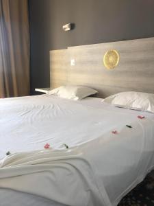 杰尔吉斯Eden Star Resort的一张配有白色床单和鲜花的大床