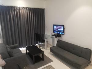 塞拉莱Hawana Salalah Laguna Studio的客厅配有2张沙发和1台平面电视