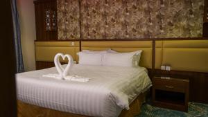 泰布克فندق جاردن فيو的两只白天鹅坐在床上