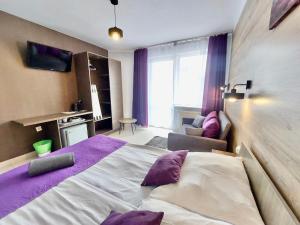 卡尔维亚Dworek Karwia Wiosenna 8的一间卧室配有一张带紫色枕头的大床