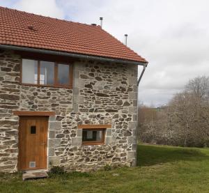 Neuvic-EntierLa Vieille Maison aux Canards的一间石头房子,设有棕色的门和窗户