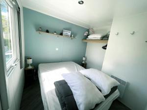 雷日卡普费雷Mobilhome climatisé 6 psn的一间小卧室,配有白色床单