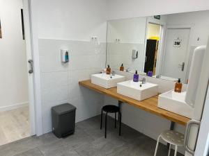 圣地亚哥－德孔波斯特拉Albergue SCQ的一间带两个盥洗盆和大镜子的浴室