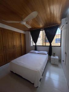 卡塔赫纳Habitaciones cerca al aeropuerto 2的卧室配有白色床和木制天花板