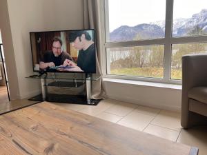 特劳恩基兴Ferienwohnung Traunkirchen mit Seeblick的客厅里靠窗的电视