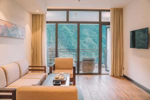张家界Zhangjiajie National Park Nvue Resorts的带沙发和大窗户的客厅