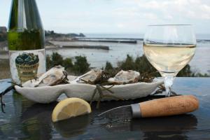 迪纳尔Proche St-Malo, plages, appart 50m2 avec jardin的一张桌子,上面放着一瓶葡萄酒和一杯