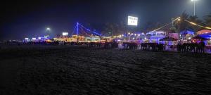 马尔冈'Golden Sand Dunes' 1bhk Benaulim beach apartment的一群桌子和帐篷在晚上在海滩上