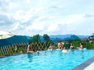 张家界Zhangjiajie National Park Nvue Resorts的一群人坐在游泳池里