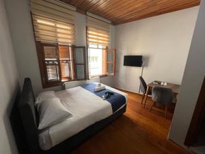 Yıldırımİnkaya hotel的一间卧室配有一张床、一张书桌和一个窗户。