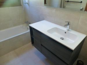 阿邦当斯Le Fayet d'en haut的浴室配有白色水槽和浴缸。
