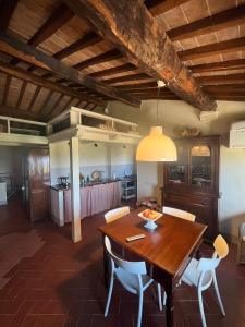 蒙特普齐亚诺Appartamento centro storico La Pulcianella的厨房以及带木桌和椅子的用餐室。