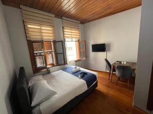 Yıldırımİnkaya hotel的一间卧室配有一张床、一张书桌和窗户。