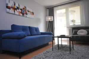 克拉科夫Aquapark with private garage by JoApart的客厅配有一张蓝色的沙发,配有一张桌子