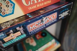 利物浦Orange Rentals - In my 4 bedroom Liverpool Home的一堆货架上的垄断棋盘游戏